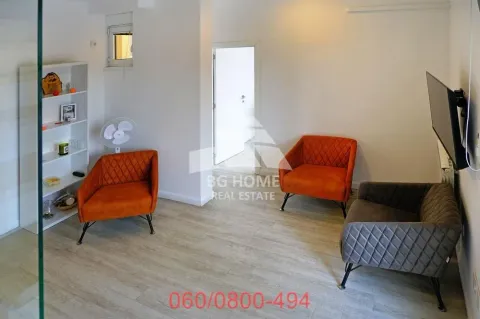 Small living room with armchairs, a shelving unit, and a television. - image 5