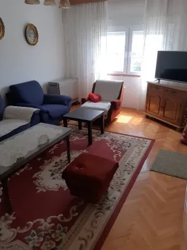A living room with seating furniture, a rug, and a television. - image 6