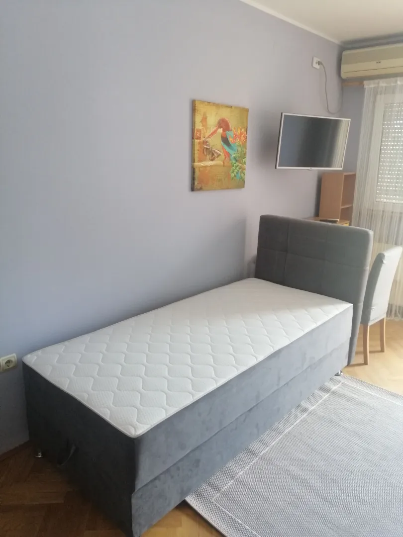 Bedroom with a bed, TV, and air conditioning.