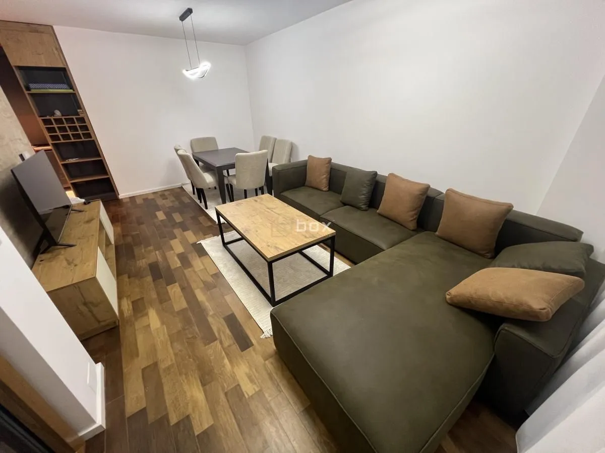 Living room with a sofa, coffee table and dining area.