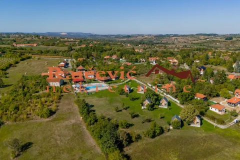 Pogled iz vazduha na imanje sa kućama, bazenom i zelenilom. - image 2