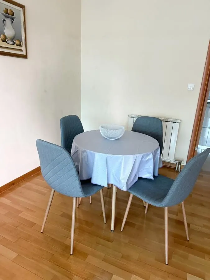 Manji trpezarijski sto sa četiri stolice u svijetloj prostoriji.