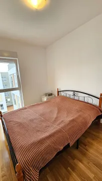Bedroom with a double bed and a window overlooking a building. - image 7