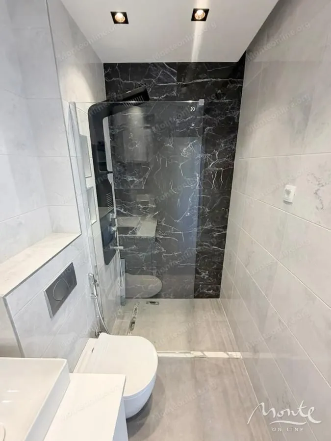 Moderne kupatilo sa tuš kabinom i ugradnom sanitarijom.