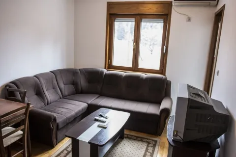 Dnevna soba sa ugaonom garniturom, klub stolom i televizorom. - image 2