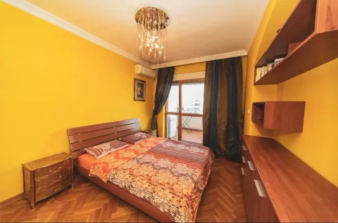 Bedroom with a double bed, wooden furniture, and yellow walls. - image 11