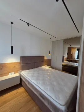 Moderna spavaća soba sa bračnim krevetom, drvenim panelima i ugradnim ormarom sa ogledalom. - image 6