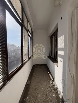 Long enclosed balcony with large windows and a city view. - image 4