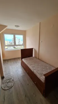 Small bedroom with a wooden bed and a city view. - image 7