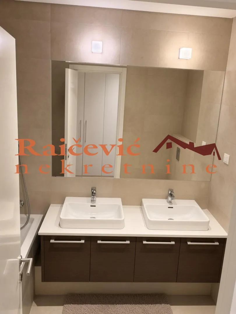 Moderno kupatilo sa duplim umivaonikom i ogledalom.