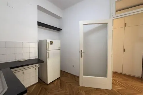 Smaller kitchen with a refrigerator and wooden flooring. - image 5