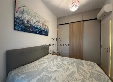 Namještena spavaća soba sa velikim bračnim krevetom, plakarom i umjetničkom slikom na zidu. - image 8