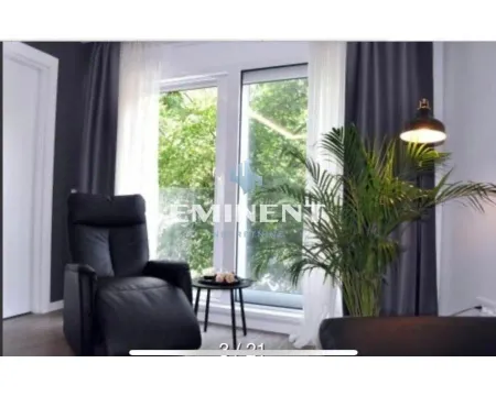 Dnevna soba sa foteljom, velikim prozorom i pogledom na zelenilo. - image 3
