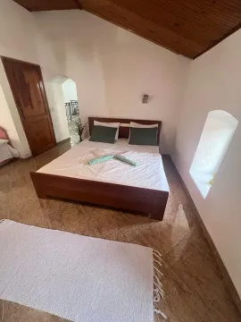 Spavaća soba sa bračnim krevetom, drvenim krovom i popločanim podom. - image 14