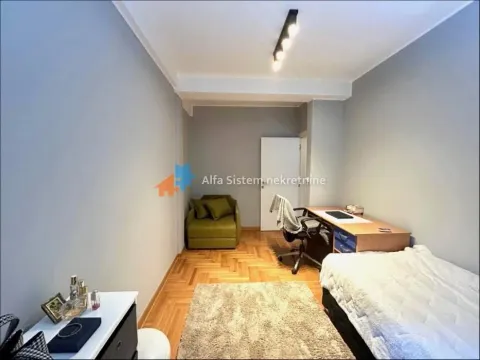 Furnished bedroom with a bed, desk, and armchair. - image 7