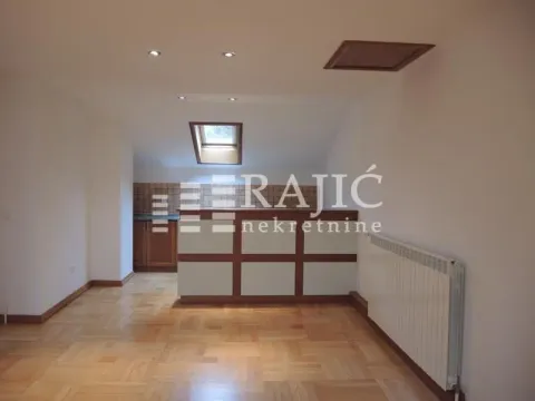 Living room with parquet flooring and a view of the kitchen with a counter. - image 7