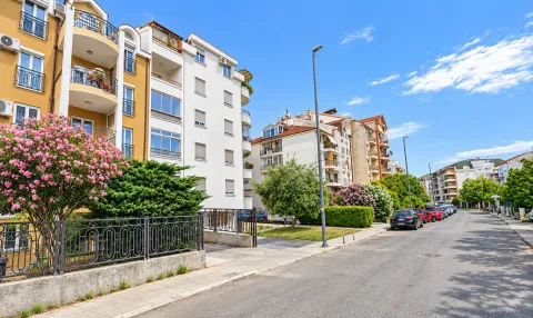 View of residential buildings and a street with greenery. - image 7