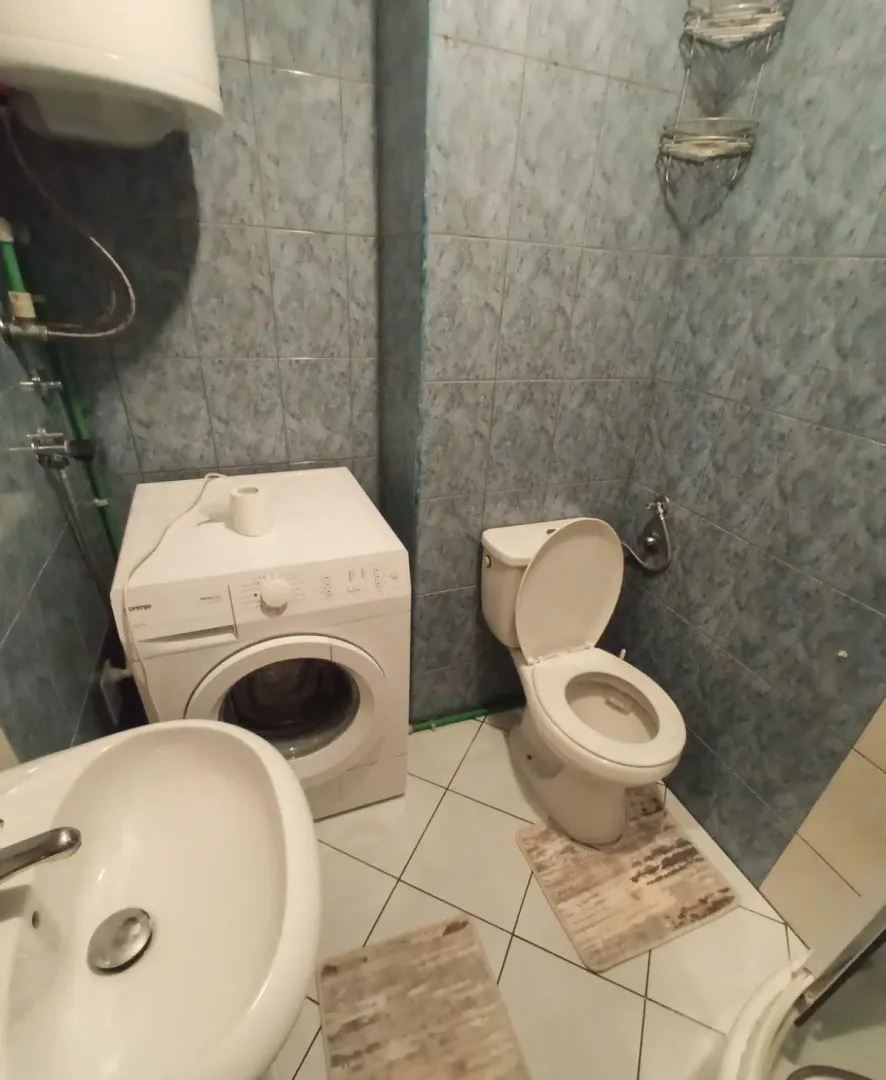 Kupatilo opremljeno sanitarijama i veš mašinom.