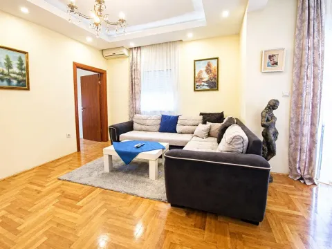 Living room with a corner sofa, coffee table, and parquet flooring. - image 4