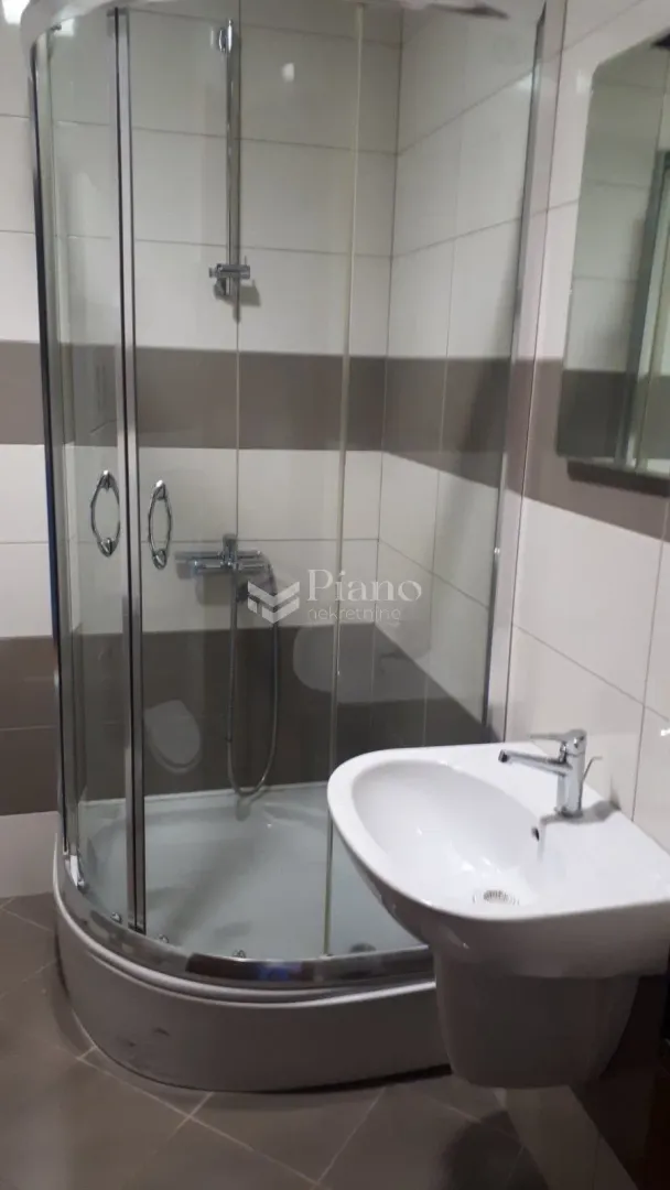Bathroom with a shower cabin and a washbasin.