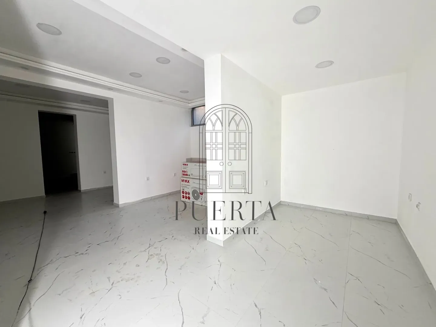 Empty bright room with white walls and ceramic floor tiles.