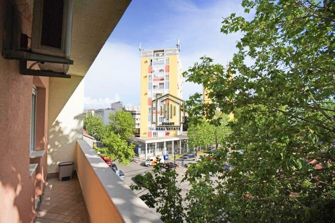 View from the balcony overlooking surrounding buildings and greenery.