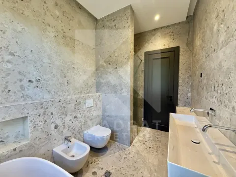 Modern bathroom tiled with ceramic tiles featuring a walk-in shower, washbasin, and sanitary fixtures. - image 6