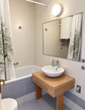 Bathroom with bathtub, washbasin, and mirror. - image 15