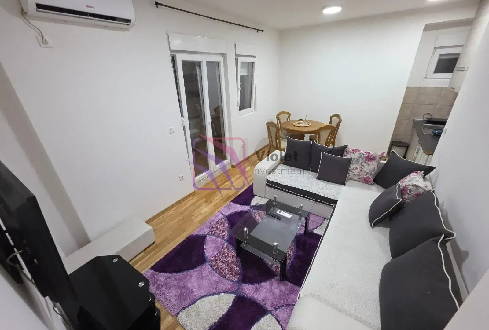 Living room with a sofa set, coffee table, and a dining table in the corner.