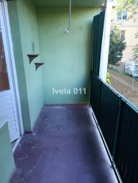 Nenamešten balkon sa zelenim zidovima i metalnom ogradom. - image 9