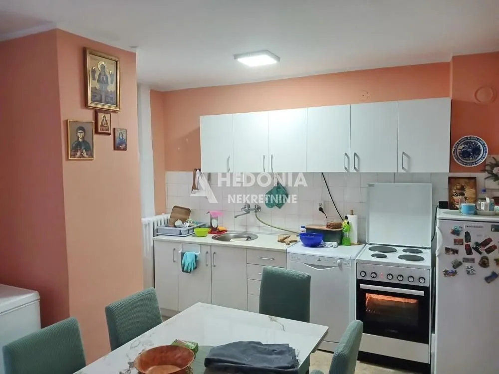 Kuhinja sa trpezarijom i belim elementima.