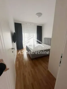 Spavaća soba sa bračnim krevetom i drvenim podom. - image 10
