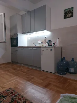 Small kitchen with grey cabinets and built-in appliances. - image 3