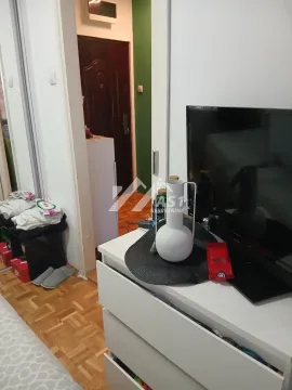 Pogled na deo spavaće sobe sa televizorom i komodom. - image 13