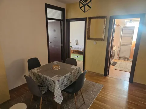 Dining area with a table and chairs, looking into other rooms of the apartment. - image 3