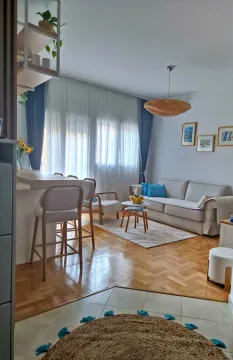Living room with sofa, dining area and parquet flooring. - image 10