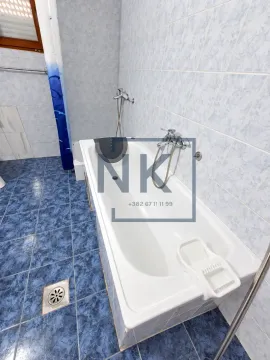 Bathroom with a bathtub and tiles on the floor and walls. - image 3
