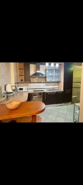 Kitchen with dark cabinets and a wooden breakfast bar. - image 4