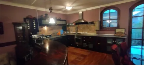 Traditional kitchen with dark wooden cabinetry and a bar counter. - image 10