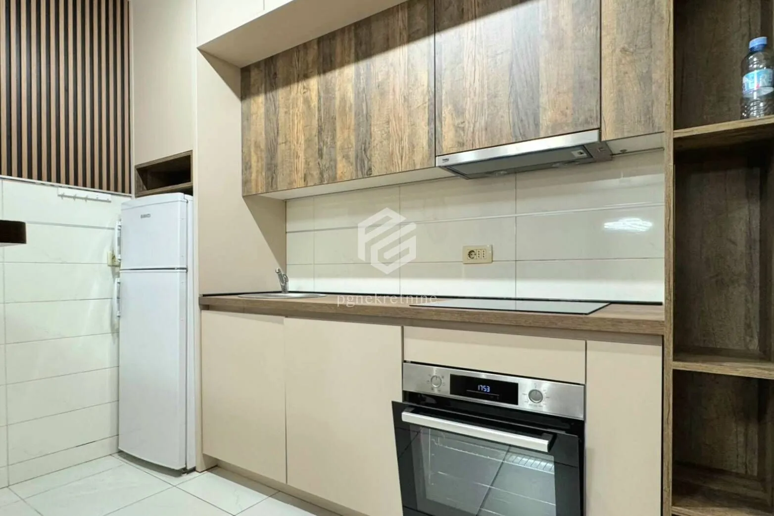 Kitchen equipped with wood-grain cabinets and white goods.