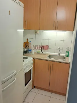 Smaller kitchen with wooden cabinets, stove, and refrigerator. - image 10