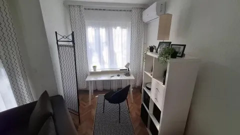 Manji dnevni boravak sa radnim stolom i belom policom. - image 6