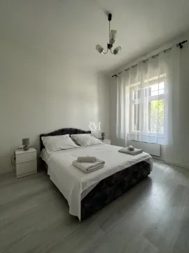 Bright bedroom with a double bed, white linens, and a window. - image 8