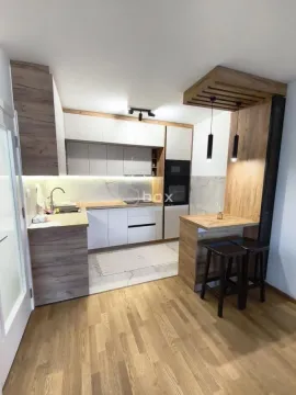 Moderna kuhinja sa drvenim elementima i šankom za ručavanje. - image 4