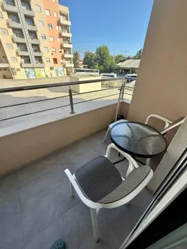 Manji namješteni balkon sa stolom i dvije stolice i pogledom na naselje. - image 7
