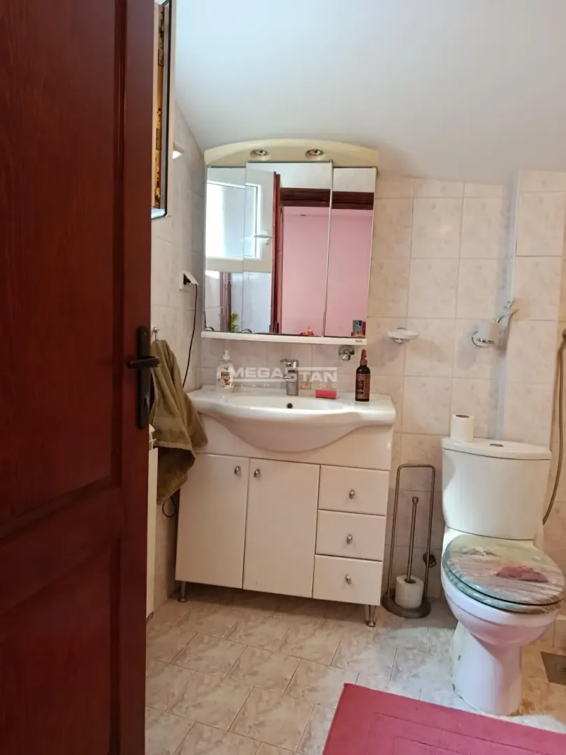 Smaller bathroom with a sink, mirror, and toilet.