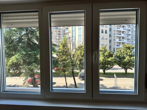 Pogled kroz prozor na okolne zgrade i zelenilo. - image 14