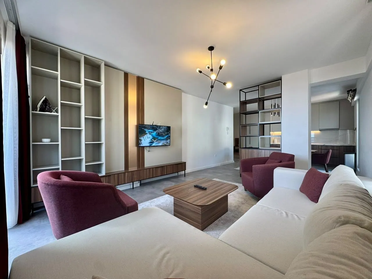 Living room with sofa, TV, and shelving unit.
