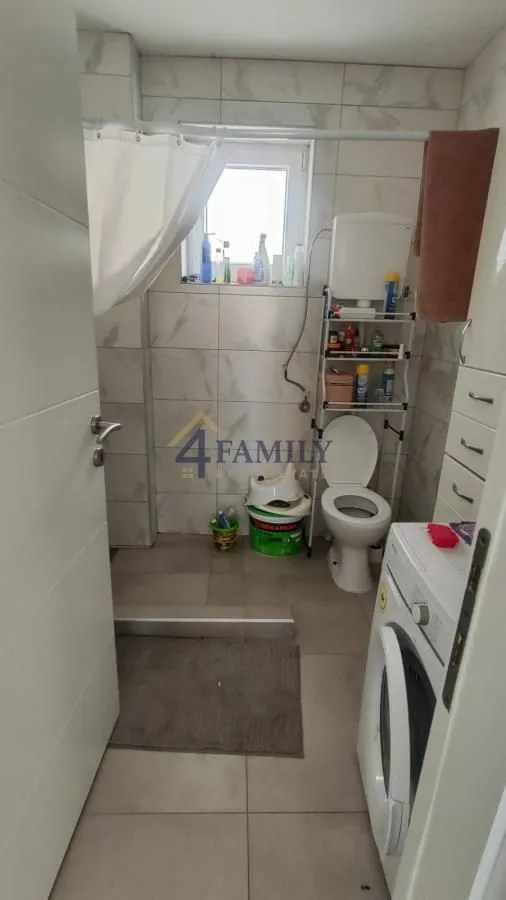 Manje kupatilo sa sanitarijama, tuš kabinom i veš mašinom.