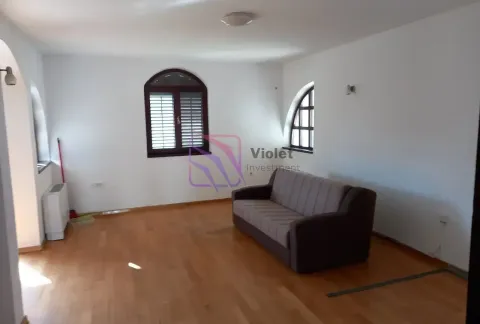 Living room with a sofa, wooden flooring, and windows of a specific shape. - image 6